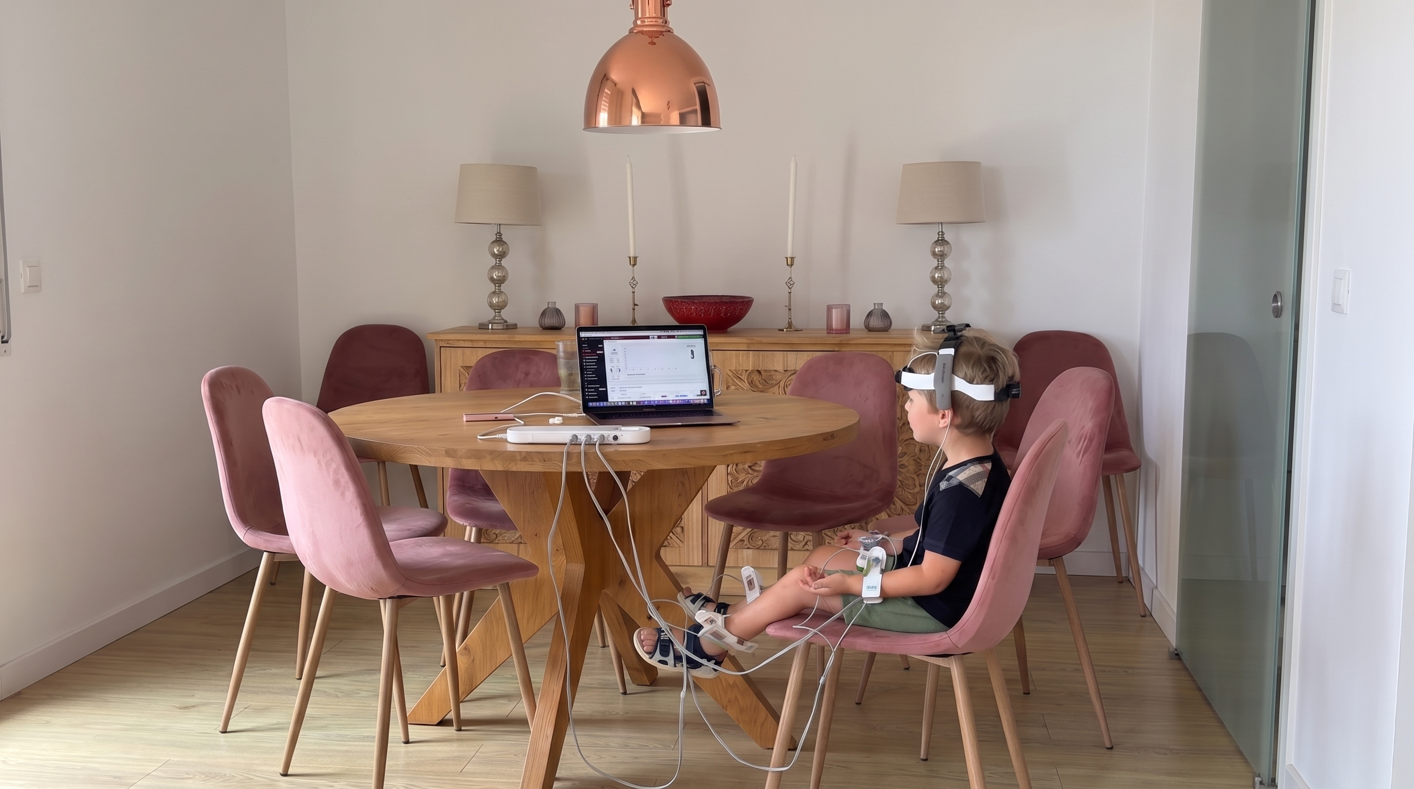 A child during a real bioresonance scanning session at home, head and limb electrodes visible